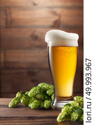keg of beer and hops on a brown wooden background. keg of beer and hops. Стоковое фото, агентство Ingram Publishing / Фотобанк Лори