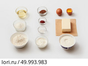 Top view of recipe with different ingredients for making cake. Ingredients for cooking represented separately over white background: oil, sugar, flour, butter, egg, etc.. Ingredients for baking or cooking. Стоковое фото, агентство Ingram Publishing / Фотобанк Лори