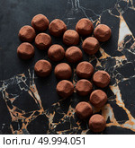 delicious chocolate truffles on a dark marble background. delicious chocolate truffles. Стоковое фото, агентство Ingram Publishing / Фотобанк Лори