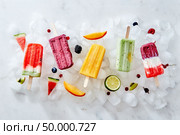 Collection of colorful tasty homemade ice cream lolly on a stick with juicy berries and pieces of various fruits on ice cubes. Flat lay. Different ice cream on a stick and different pieces of fruit and berries on ice cubes. Flat lay. Стоковое фото, агентство Ingram Publishing / Фотобанк Лори