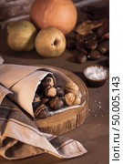 Roasted chestnuts in a paper cone, on a rustic kitchen countertop. Стоковое фото, агентство Ingram Publishing / Фотобанк Лори