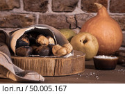 Roasted chestnuts in a paper cone, on a rustic kitchen countertop. Стоковое фото, агентство Ingram Publishing / Фотобанк Лори