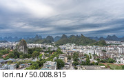 Panorama of a modern city. Lots of buildings, green trees. There is a pavilion on top of a high sheer cliff. Silhouettes of mountains on the horizon. Clouds, sky. China.Guilin.View from the Fubo Hill. Стоковое фото, фотограф Вера Ивановна Кубарева / Фотобанк Лори