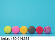 Cake macaron or macaroon on turquoise background from above, colorful almond cookies, pastel colors, vintage card. Стоковое фото, агентство Ingram Publishing / Фотобанк Лори