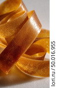 Close up of shimmering golden ribbon loops. Стоковое AI-изображение, AI-художник Юрий Поздников / Фотобанк Лори