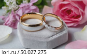 Wedding rings resting on a velvet cushion with pink roses. Стоковое AI-видео, аниматор Юрий Поздников / Фотобанк Лори