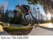 Skateboarder dropring a ramp at sunset at the local skatepark. Стоковое фото, агентство Ingram Publishing / Фотобанк Лори