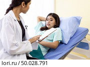 Patient fell worry when Asian Doctor make routine health check in hospital ward. Стоковое фото, агентство Ingram Publishing / Фотобанк Лори
