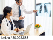 Professional doctors discussion about x-ray result in medical office hospital. Стоковое фото, агентство Ingram Publishing / Фотобанк Лори
