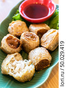 Hoi Jo, Deep Fried Crab Meat Rolls with sweet plum sauce. Thai street food and restaurant cuisine on wooden table. Стоковое фото, агентство Ingram Publishing / Фотобанк Лори
