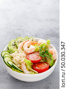 Hawaiian poke bowl with shrimps, rice and vegetables, healthy Buddha bowl with prawns, rice, avocado, cucumber, tomato and lettuce. Стоковое фото, агентство Ingram Publishing / Фотобанк Лори