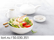 Hawaiian poke bowl with shrimps, rice and vegetables, healthy Buddha bowl with prawns, rice, avocado, cucumber, tomato and lettuce. Стоковое фото, агентство Ingram Publishing / Фотобанк Лори