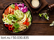 Buddha bowl dish. Healthy balanced lunch with quinoa, grilled chicken meat, lettuce salad, pepper, cucumber, tomato and avocado guacamole with lemon. Стоковое фото, агентство Ingram Publishing / Фотобанк Лори