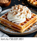 Waffles with whipped cream on a dark background. Generated by AI. Стоковое AI-изображение, AI-художник Анна Никонорова / Фотобанк Лори
