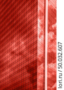 Urban glass business skyscraper with shadows and reflections of sky clouds on a shiny surface in a fashionable pantone trendy color of spring-summer 2019 season.. Modern glass business center building with reflection of a cloudy sky in a trendy color of the year 2019 Living Coral pantone . Стоковое фото, агентство Ingram Publishing / Фотобанк Лори