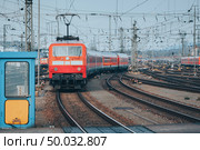 Railway station with modern red commuter train  in motion in the evening in Nuremberg, Germany. Red train on the railroad track with vintage toning. Стоковое фото, агентство Ingram Publishing / Фотобанк Лори
