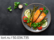 Grilled salmon fish steak, asparagus, tomato and corn salad on plate. Healthy dish for lunch. Top view. Стоковое фото, агентство Ingram Publishing / Фотобанк Лори