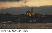 Night view of Eminonu Harbor, Beyoglu district historic architecture and Muslim Mosque in Istanbul Turkey on a nightfall sky. 4K UHD video, 3840, 2160p.. Old town Istanbul in prayer time. Looking over Golden Horn to Suleymaniye Mosque on a twilight sky. 4K UHD video, 3840, 2160p. Стоковое фото, агентство Ingram Publishing / Фотобанк Лори