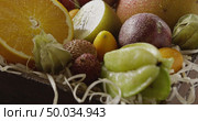 Variety of tropical fruits - halves of orange, pineapple, carambola, coconut and lichi are pouring water. Panoramic motion, 4K UHD video, 3840, 2160p. Concept of vegetarian diet eating.. Pouring water on a fresh organic natural exotic fruits. Close-up video. Panoramic motion, 4K UHD video, 3840, 2160p. Стоковое фото, агентство Ingram Publishing / Фотобанк Лори