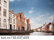 view canal and colorful traditional houses against cloudy blue sky in popular belgian destination, Brugge, Belguim. view canal and colorful traditional houses against cloudy blue sky. Стоковое фото, агентство Ingram Publishing / Фотобанк Лори