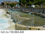 People walking near natural travertines pools and terraces in Pamukkale. Редакционное фото, фотограф Маргарита Кирьякова / Фотобанк Лори