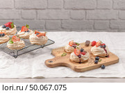 Small pavlova cakes with fresh raspberries and blueberries. Стоковое фото, агентство Ingram Publishing / Фотобанк Лори