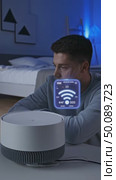 Young man interacting with smart home air purifier displaying wifi connection status in modern bedroom. Стоковое AI-видео, аниматор Владимир Федоров / Фотобанк Лори