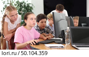 Interested preteen boys and girls working on computer together with teacher in IT cabinet. Стоковое видео, видеограф Яков Филимонов / Фотобанк Лори