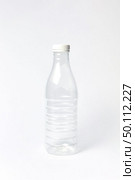 Transparent empty plastic bottle for water or other liquid on a light background, mock up. Place for text.. Empty plastic bottle mock up for water on a light background. Стоковое фото, агентство Ingram Publishing / Фотобанк Лори