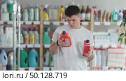 Young man choosing unclogging gel in store. Стоковое видео, видеограф Яков Филимонов / Фотобанк Лори
