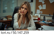 Woman in office contemplating at cluttered desk. Стоковое AI-изображение, AI-художник Андрей Бакусов / Фотобанк Лори