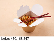 Delicious noodles with colorful vegetables are neatly packed in a white takeout box. Стоковое фото, фотограф Виктория Тельминова / Фотобанк Лори