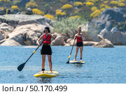 Stand up paddleboarding on lake. Watersport on lake. Tourist outdoor activity at Lagoa Comprida, Serra da Estrela National Park in Portugal. Стоковое фото, агентство Ingram Publishing / Фотобанк Лори