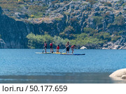 Stand up paddleboarding on lake. Watersport on lake. Tourist outdoor activity at Lagoa Comprida, Serra da Estrela National Park in Portugal. Стоковое фото, агентство Ingram Publishing / Фотобанк Лори