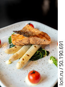 Grilled Salmon Fillet with grilled white asparagus serve with tomato and spinach. Стоковое фото, агентство Ingram Publishing / Фотобанк Лори