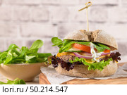 Healthy vegan burger with fresh vegetables and yogurt sauce on rustic kitchen counter top. Стоковое фото, агентство Ingram Publishing / Фотобанк Лори
