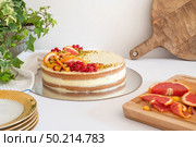 Homemade vanilla birthday cake decorated with orange, peach and gooseberries isolated on table tob. Celebration, party cake. Стоковое фото, агентство Ingram Publishing / Фотобанк Лори