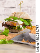 Healthy vegan burger with fresh vegetables and yogurt sauce on rustic kitchen counter top. Стоковое фото, агентство Ingram Publishing / Фотобанк Лори