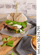 Healthy vegan burger with fresh vegetables and yogurt sauce on rustic kitchen counter top. Стоковое фото, агентство Ingram Publishing / Фотобанк Лори