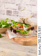 Healthy vegan burger with fresh vegetables and yogurt sauce on rustic kitchen counter top. Стоковое фото, агентство Ingram Publishing / Фотобанк Лори