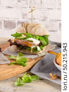 Healthy vegan burger with fresh vegetables and yogurt sauce on rustic kitchen counter top. Стоковое фото, агентство Ingram Publishing / Фотобанк Лори