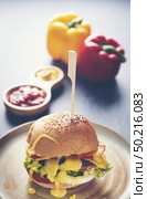 A delicious grilled Angus burger with cheese, lettuce, and tomato on a sesame seed bun. Стоковое фото, агентство Ingram Publishing / Фотобанк Лори