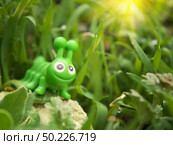 Toy caterpillar in grass. Conceptual scene. Стоковое фото, агентство Ingram Publishing / Фотобанк Лори