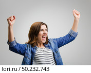 Studio portrait of a successful woman with arms raised. Стоковое фото, агентство Ingram Publishing / Фотобанк Лори