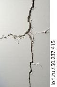 Fissures snake through an otherwise pristine white wall, hinting at structural issues and the inevitable wear of years. Light plays on the jagged lines, creating depth Generative AI. Стоковое AI-изображение, AI-художник Юлия Петровская / Фотобанк Лори