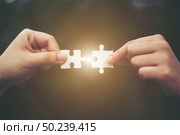 Hand holding jigsaw puzzles, Business partnership concept. Стоковое фото, агентство Ingram Publishing / Фотобанк Лори
