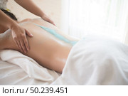 Beautiful woman getting a salt scrub beauty treatment in the health spa. Стоковое фото, агентство Ingram Publishing / Фотобанк Лори