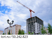 Строящееся многоэтажное здание жилой дом, высотный кран, железобетонные конструкции / A multi-storey building under construction, an apartment building, a high-rise crane, reinforced concrete structures. Стоковое фото, фотограф Roman Savateev / Фотобанк Лори