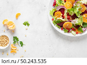 Christmas salad with boiled beet, red onion, tangerines, pomegranate, parsley, pine nuts and lettuce leaves. Стоковое фото, агентство Ingram Publishing / Фотобанк Лори