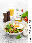 Pasta cavatappi with spinach pesto, tomatoes and fried egg in bowl served for lunch. Стоковое фото, агентство Ingram Publishing / Фотобанк Лори